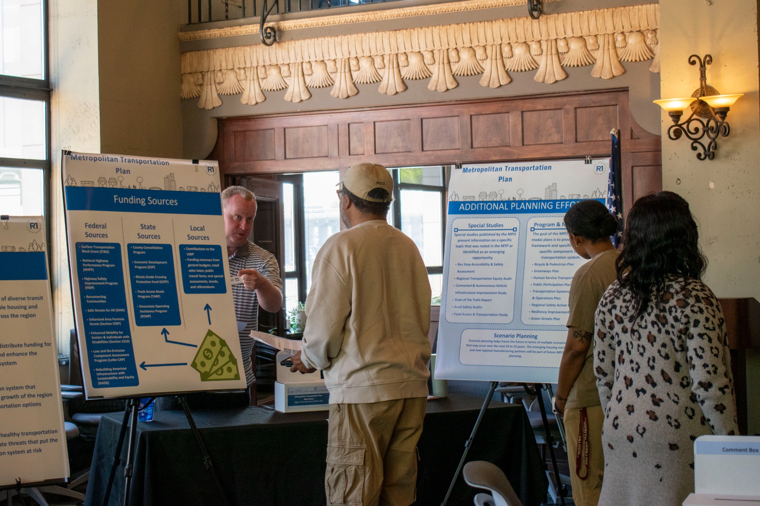 Image of R1 staff member describing a poster to community members at the MTP Open House Event in 2025.